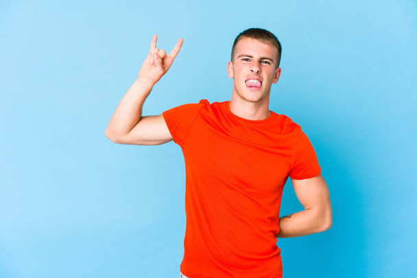 młody biały przystojny mężczyzna pokazując rock gest z palce - Zdjęcie, obraz