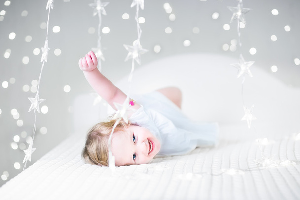 kisgyermek lány játszik egy fehér ágy - Fotó, kép