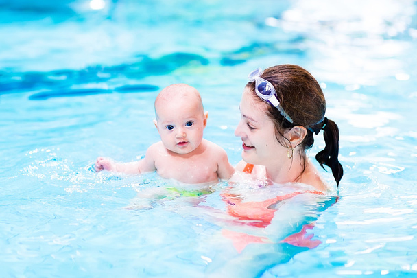 Poikavauva nauttii uima-altaassa oppitunnista äitinsä kanssa
 - Valokuva, kuva