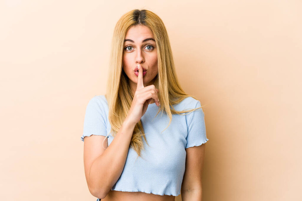 Young blonde caucasian woman keeping a secret or asking for silence. - Foto, Bild
