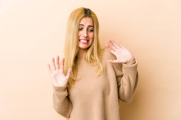 Jeune femme caucasienne blonde rejetant quelqu'un montrant un geste de dégoût. - Photo, image