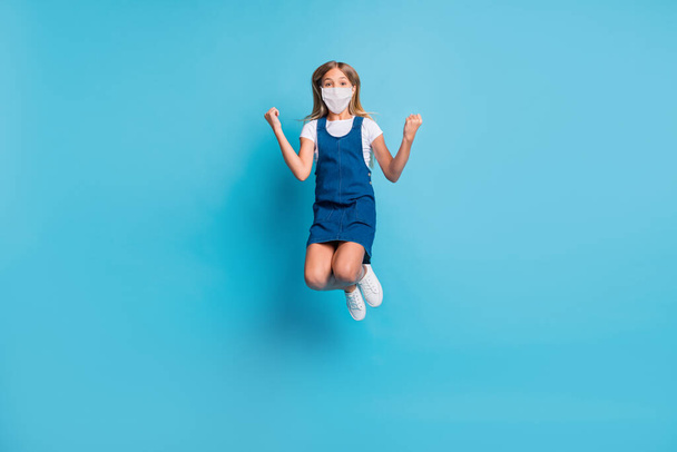 Full size photo of hooray girl jumping wear facial mask t-shirt dress shoes isolated on pastel blue color background - Foto, imagen
