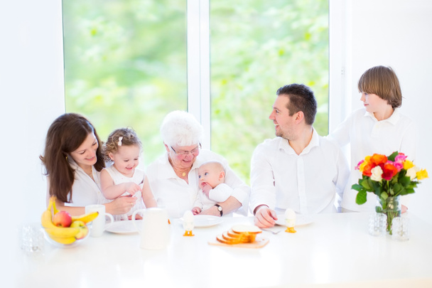 Família com três crianças se divertindo juntas durante um café da manhã de Páscoa
 - Foto, Imagem