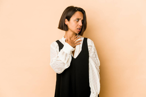 Mujer hispana joven aislada tocando la parte posterior de la cabeza, pensando y tomando una decisión. - Foto, Imagen