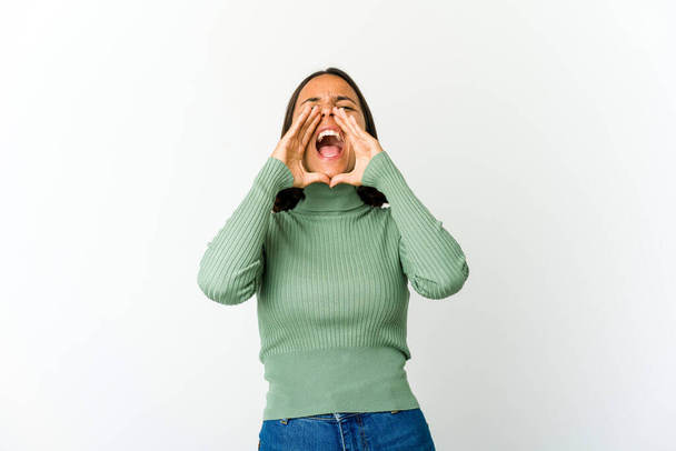 Young mixed race woman shouting excited to front. - 写真・画像