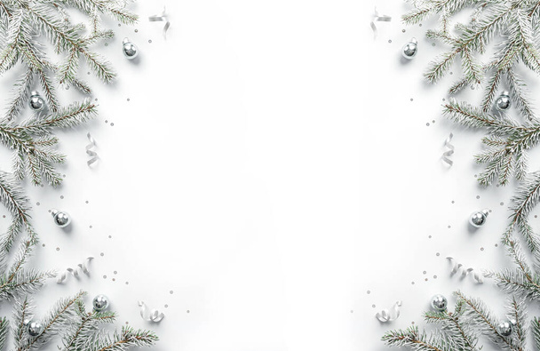 Beyaz arkaplandaki beyaz köknar dallarından yapılmış mutlu Noeller çerçevesi gümüş süsleme, parıltı, bokeh, ışık. Noel ve yeni yıl tebrik kartı, kış tatili. Düz konum, üst görünüm, pankart - Fotoğraf, Görsel
