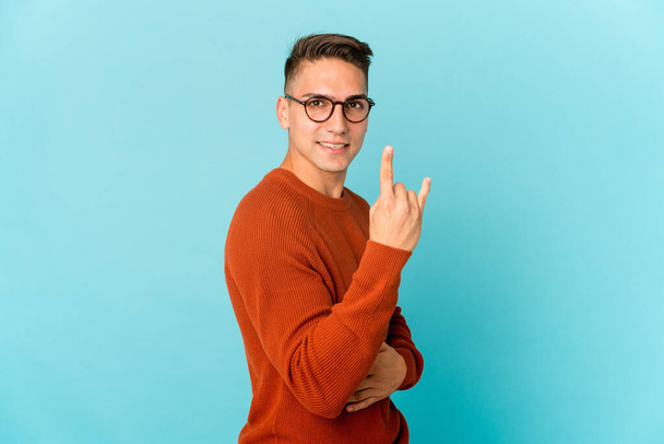 Giovane caucasico bell'uomo isolato mostrando gesto rock con le dita - Foto, immagini