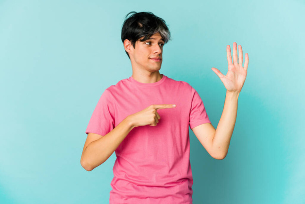 Young skinny hispanic man posing on color background  - Photo, Image