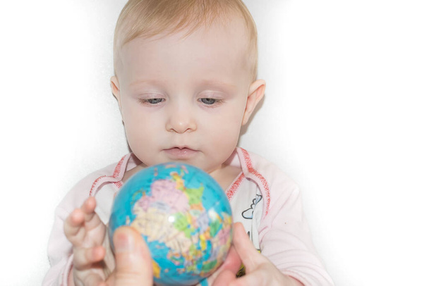 Little child examines the globe - 写真・画像