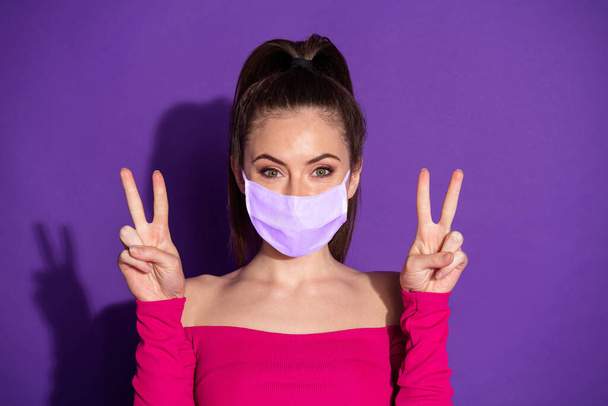 Photo of candid sweet girl two hands make v-sign wear medical respiratory isolated over violet color background - Foto, Imagen