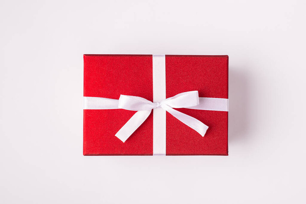 Top close up above overhead view photo of rectangular giftbox with small white bow isolated white background - Photo, Image