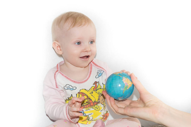 Little child examines the globe - Foto, afbeelding