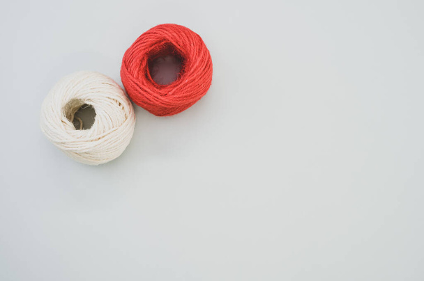 The red and white yarn balls isolated on gray background - Foto, afbeelding