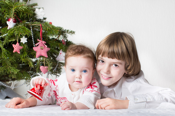 Χριστούγεννα πορτρέτο του ένα μικρό αγόρι και η αδελφή του αξιολάτρευτο μωρό - Φωτογραφία, εικόνα