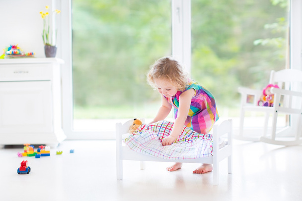 Девочка-игрушка, играющая со своим медведем
 - Фото, изображение