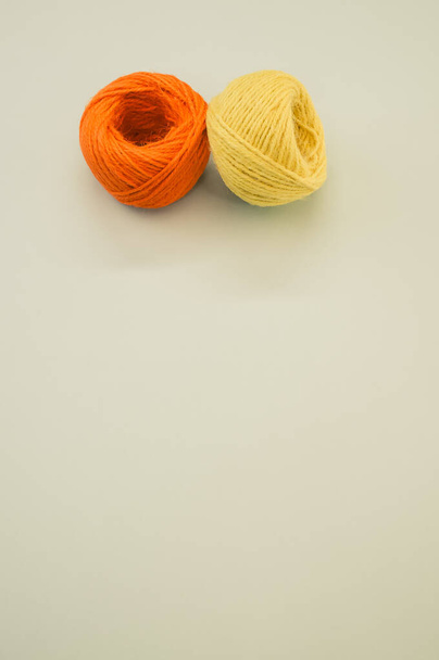 An orange and yellow yarn balls for knitting isolated on gray background - Zdjęcie, obraz