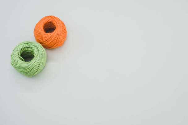 An orange and green yarn balls isolated on gray background - Фото, зображення