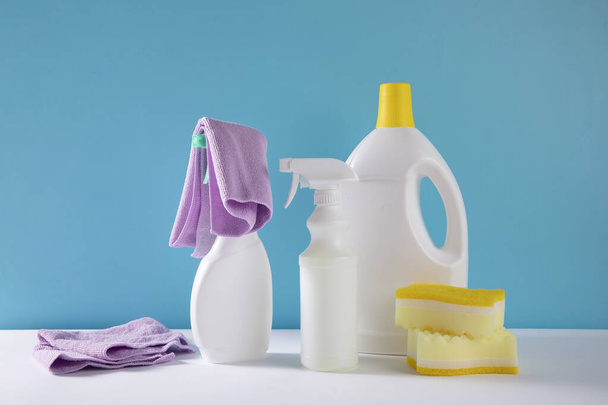 The bottles of sanitizers and sprays with sponges by a blue background - Photo, Image