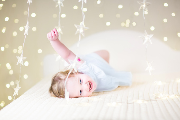 maluch dziewczyna gra w białe łóżko - Zdjęcie, obraz