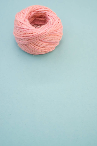 A pink yarn ball for knitting isolated on blue background - Fotografie, Obrázek