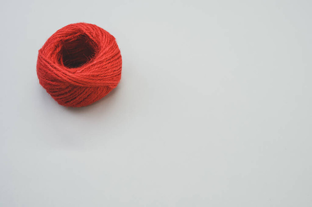 A red yarn ball isolated on gray background - Foto, Bild