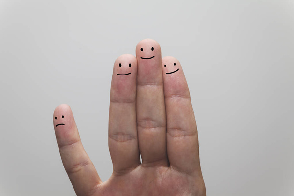 Ένα κοντινό πλάνο μιας χαρούμενης ομάδας δακτύλων, το ένα διαχωρίζεται από τα άλλα. - Φωτογραφία, εικόνα