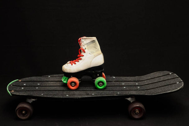 A closeup shot of a white roller skate on a black skateboard - Фото, зображення