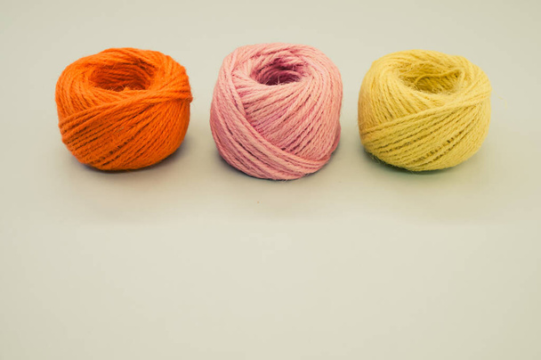 Three colorful yarn balls for knitting isolated on gray background - Foto, imagen