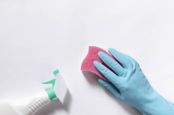 A top view closeup of cleaning gloves, sponge, and spray bottle on a white background - Photo, image