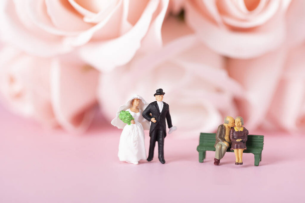 A selective focus shot of bride, groom, and elderly couple miniature figurines - Foto, immagini