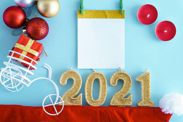 Xmas, winter, new year concept - layout white plate on which there are three Christmas trees cut from sausage cheese bread with santa hat and golden candles in form of numbers 2021 Blue background - Fotó, kép