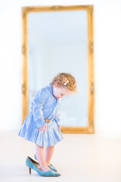 Девушка стоит перед большим зеркалом
 - Фото, изображение
