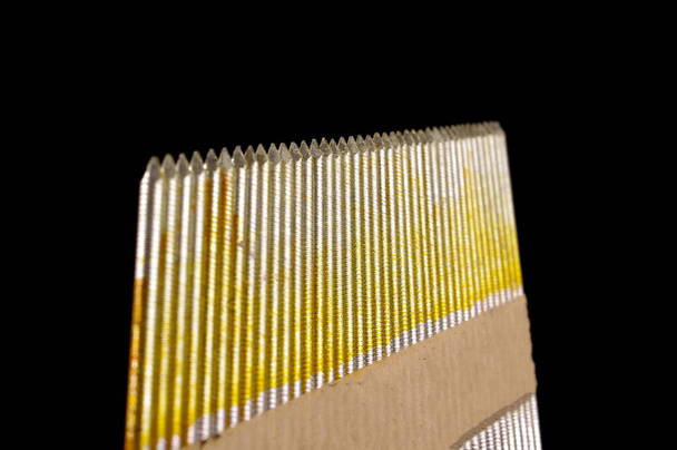 Упаковка промышленных строительных гвоздей для конструкций, изолированных на черном фоне - Фото, изображение
