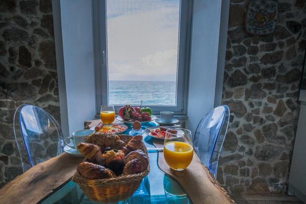窓から海を眺めながら朝食を, Cefalu,シチリア島の中世の村,パレルモ県,イタリア - 写真・画像