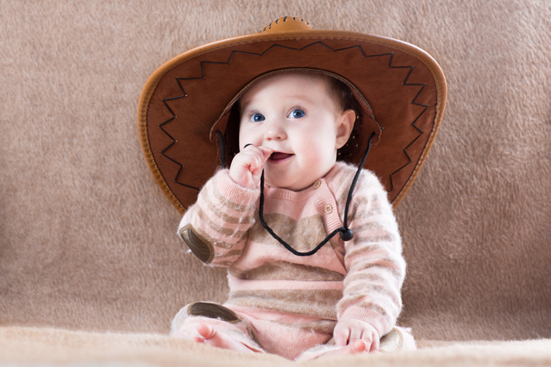 Bebé vistiendo un traje de chica vaca con un gran sombrero
 - Foto, Imagen