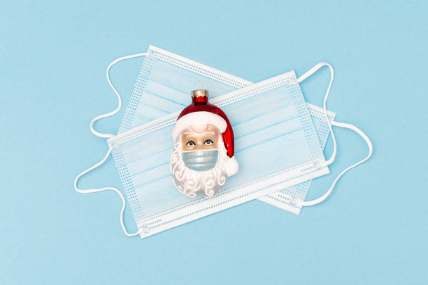 Christmas ornament Santa Claus and protective face mask. Coronavirus pandemic lockdown health care concept - Foto, Imagem