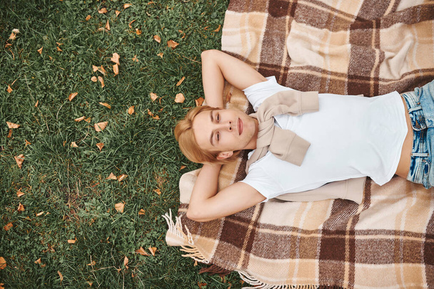 Handsome man having rest outdoors. Lying on blanket in park. - Foto, Imagen