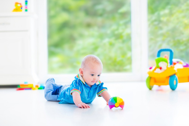 Чарівний хлопчик грає з барвистим м'ячем та іграшковим автомобілем
 - Фото, зображення