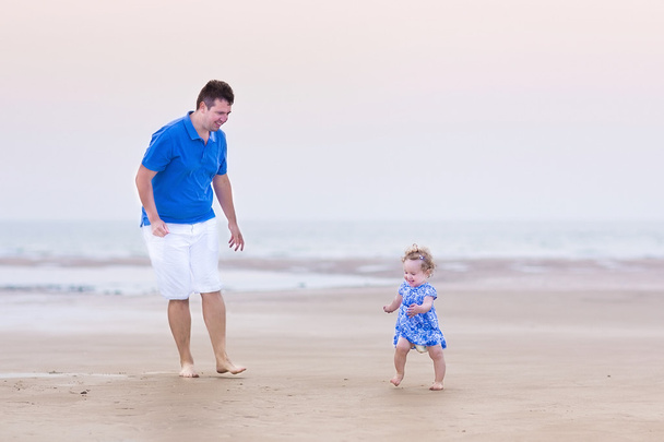 Pai com sua filha em uma praia
 - Foto, Imagem