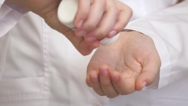 Primo piano della mano dei medici caucasici che contano pillole blu al dito. Il giovanotto sta raccogliendo le tavolette sul palmo della mano. C'è un tema del trattamento farmacologico. Concetto di medicina e assistenza sanitaria - Filmati, video