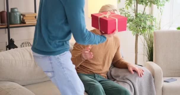 Gay man giving surprise gift to his boyfriend - Materiał filmowy, wideo