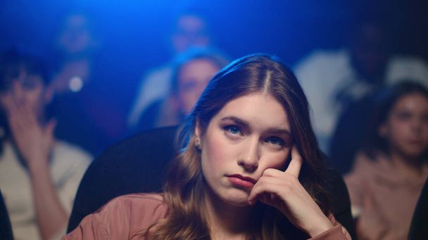 Frustrovaná žena kouká na nudný film. Rozrušená dívka zívá v kině. - Fotografie, Obrázek