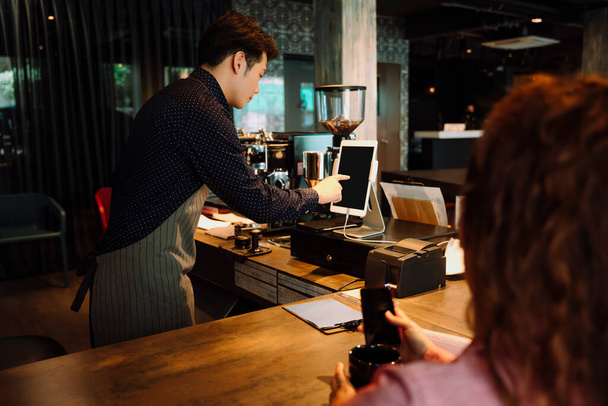 Barman dělá jídlo a vaření účet v digitální tabletu v kavárně. - Fotografie, Obrázek
