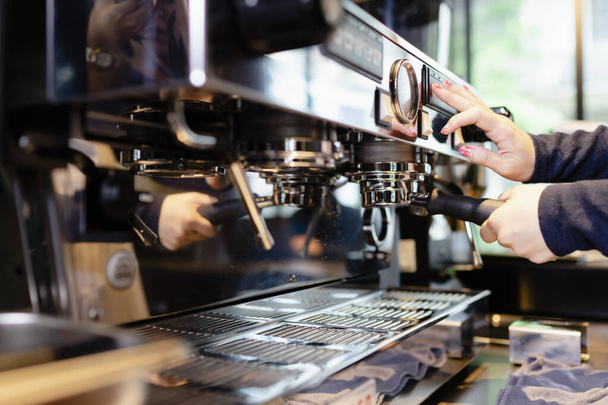 カフェで機械とコーヒーを作るバリスタの手を閉じる. - 写真・画像