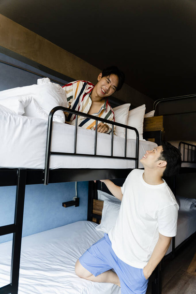 Due uomini asiatici si divertono a parlare tra loro in camera da letto. - Foto, immagini