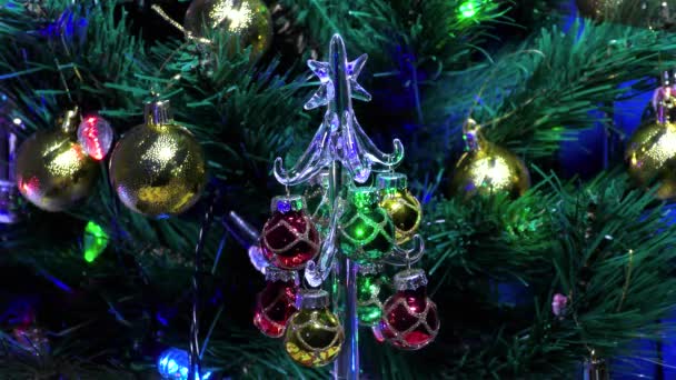 Piccolo albero di Natale di vetro sullo sfondo di un grande albero di Natale verde - Filmati, video