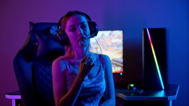 Tatoué gamer fille assis près du PC et sucer une sucette - Séquence, vidéo