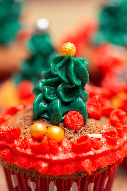 クリスマスはバタークリームアイシングとスプリンクルでミニカップケーキを飾りました. - 写真・画像
