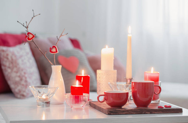 Burning candles on white table in interior. Valentines day concept - Φωτογραφία, εικόνα