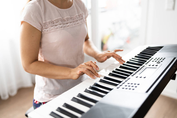 Woman Playing Music Keyboard Piano Instrument At Home - 写真・画像